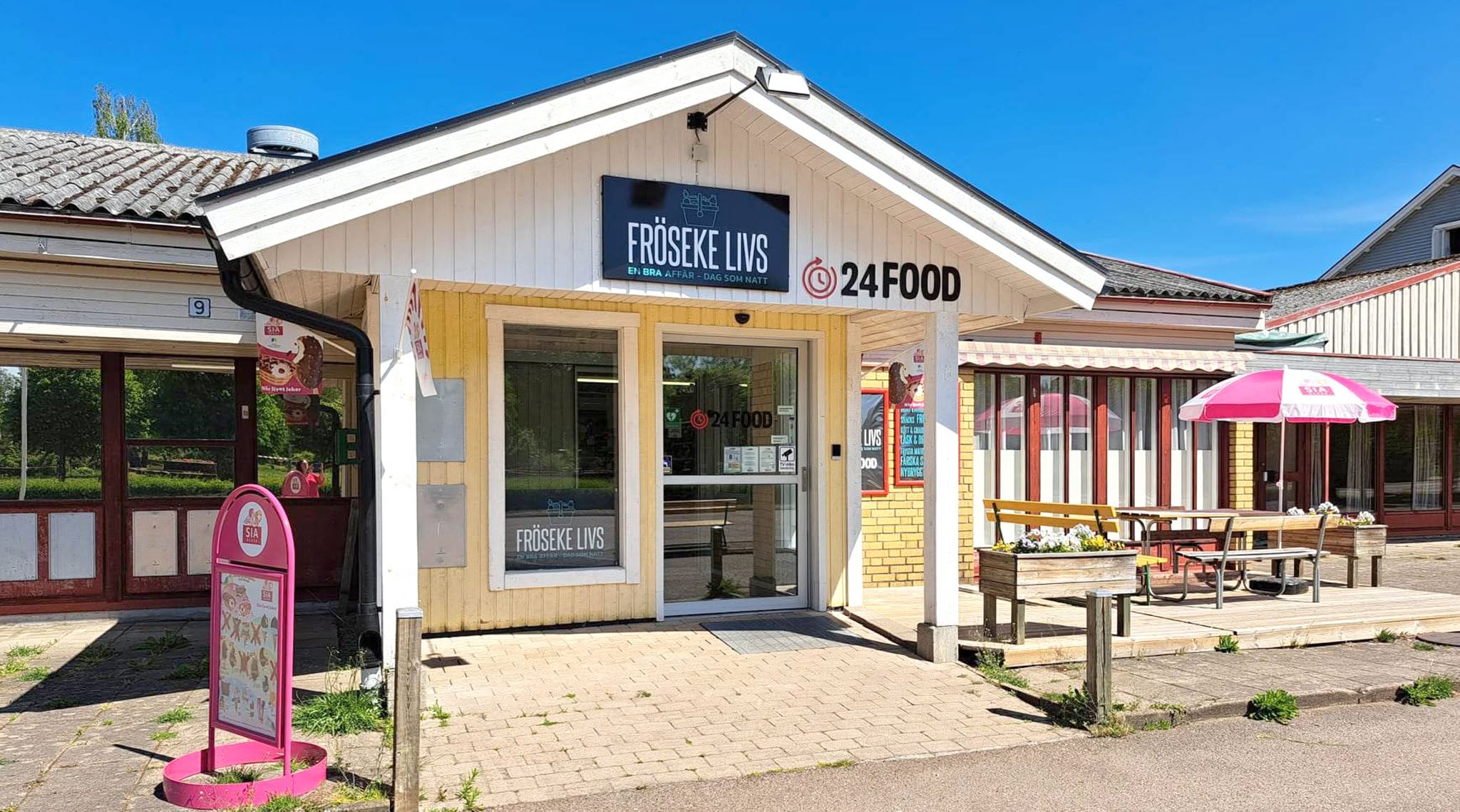 Entrén till Fröseke Livs och 24Food på Nybrovägen 9, med gul fasad och uteplats
